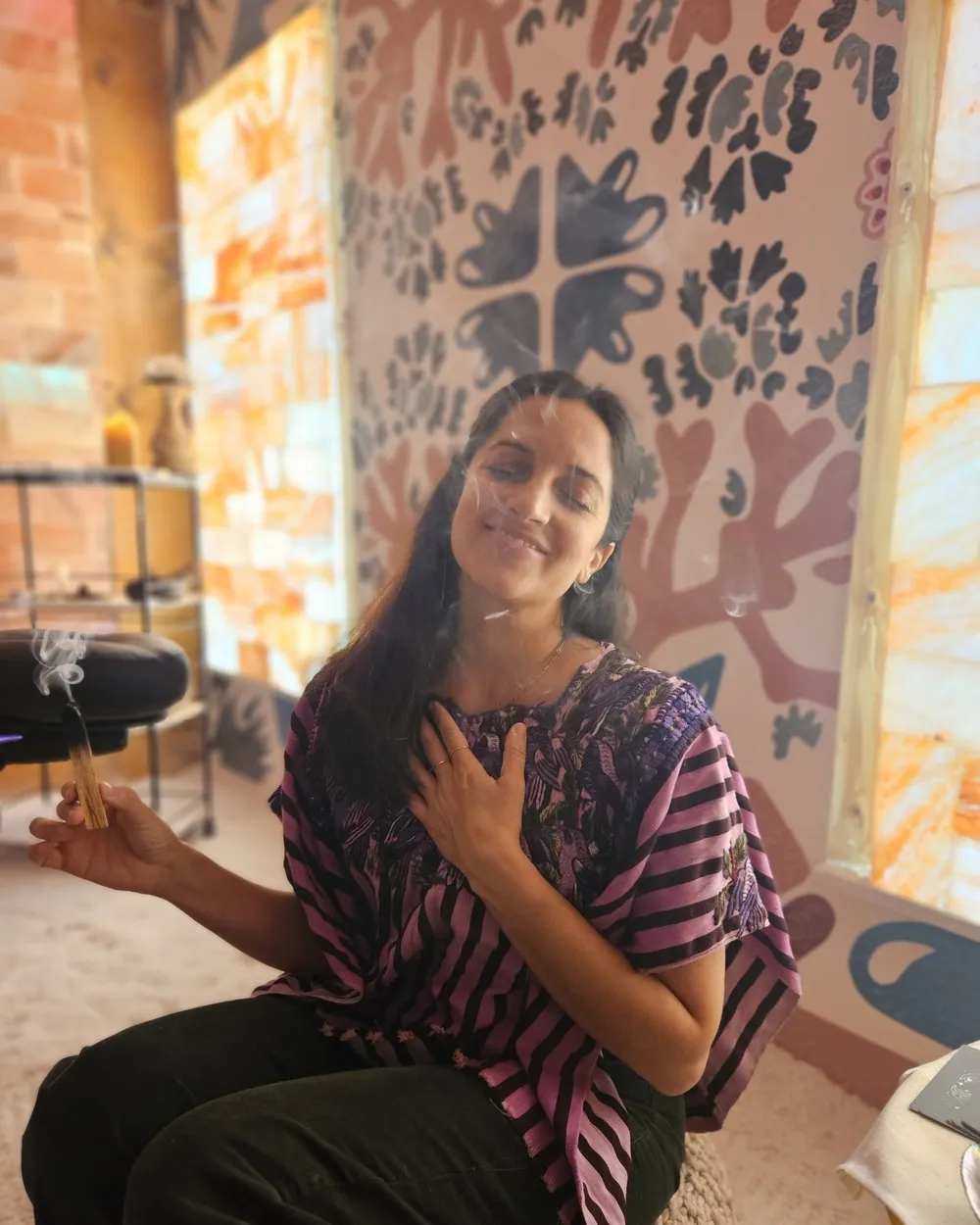 Jarin holding palo santo in the salt room